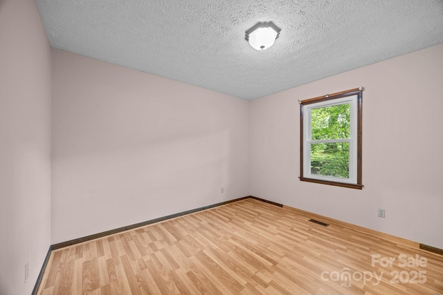 1128 Forest St, Mars Hill, NC 28754 - empty room featuring wood finished floors, a textured ceiling, and baseboards