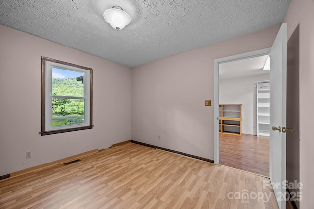 1128 Forest St, Mars Hill, NC 28754 - spare room with light wood-type flooring, a textured ceiling, and baseboards