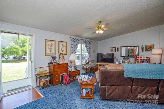 carpeted living area featuring ceiling fan, a textured ceiling, lofted ceiling, and ornamental molding