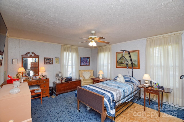 carpeted bedroom featuring a ceiling fan and a textured ceiling