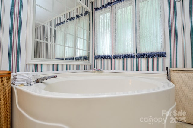 bathroom featuring a garden tub and wallpapered walls