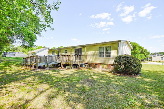 rear view of property featuring a lawn, a deck, and crawl space