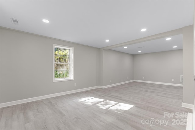 spare room featuring light wood-style floors, recessed lighting, baseboards, and visible vents