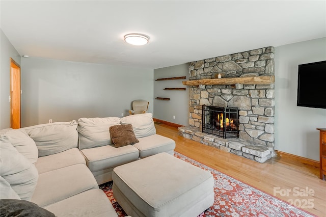 living room featuring baseboards, wood finished floors, and a fireplace