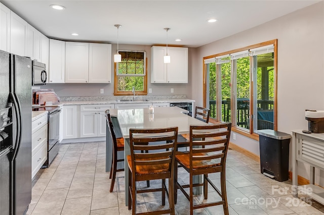 kitchen featuring range with electric stovetop, recessed lighting, white cabinets, a sink, and black fridge