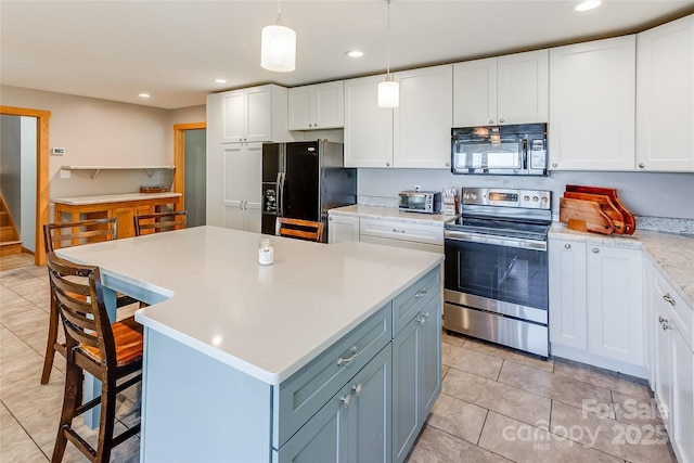 kitchen with light countertops, white cabinetry, a kitchen island, and black appliances