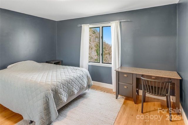 bedroom with light wood-style floors and baseboards