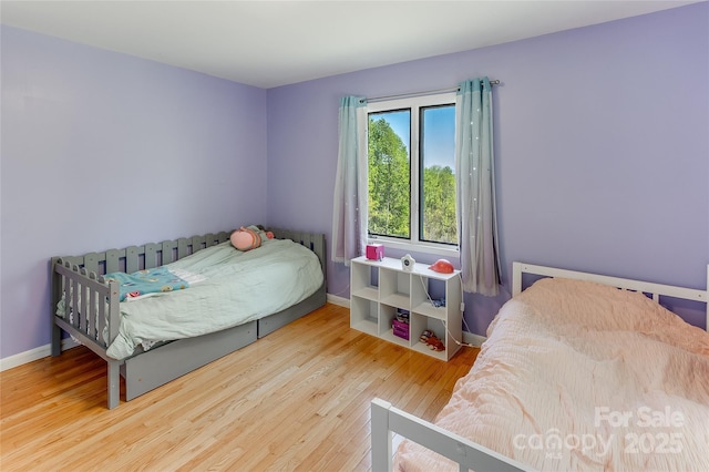 bedroom featuring baseboards and wood finished floors
