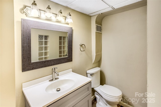 bathroom featuring vanity, visible vents, and toilet