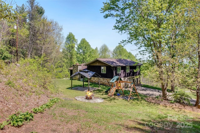 view of play area with a gazebo, a fire pit, and a lawn
