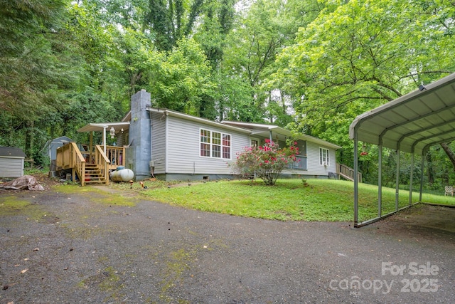 857 Hills Rd, Belmont, NC 28012 - view of front facade with crawl space, a chimney, a front yard, a storage shed, and an outbuilding