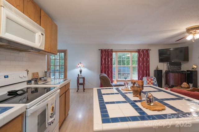 857 Hills Rd, Belmont, NC 28012 - kitchen featuring backsplash, a ceiling fan, tile countertops, open floor plan, and white appliances