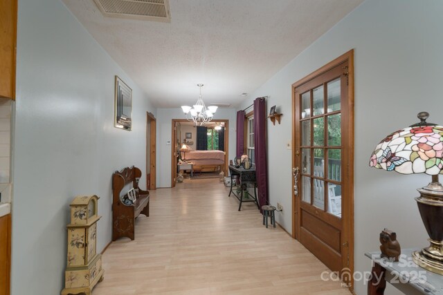 857 Hills Rd, Belmont, NC 28012 - entryway with light wood-style floors, a healthy amount of sunlight, an inviting chandelier, and visible vents