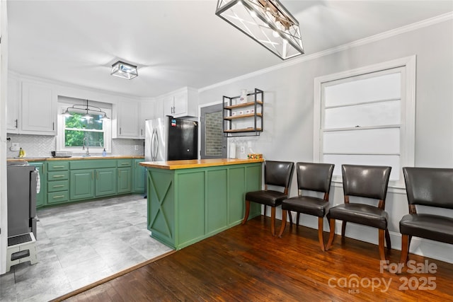 851 Gist Rd, Rock Hill, SC 29732 - kitchen with butcher block countertops, green cabinetry, a sink, freestanding refrigerator, and decorative backsplash