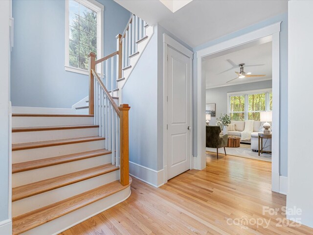 3825 Mountain Cove Dr, Charlotte, NC 28216 - stairs with wood finished floors, a ceiling fan, and baseboards