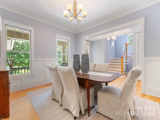 3825 Mountain Cove Dr, Charlotte, NC 28216 - dining space featuring a chandelier, light wood finished floors, wainscoting, stairway, and ornamental molding