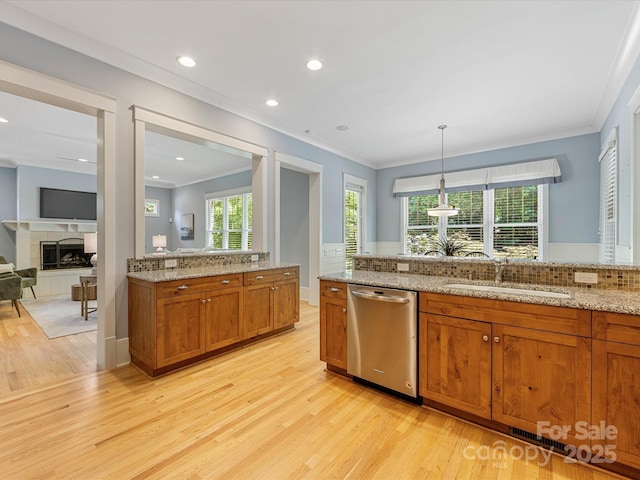 3825 Mountain Cove Dr, Charlotte, NC 28216 - kitchen with stainless steel dishwasher, light wood finished floors, crown molding, brown cabinets, and healthy amount of natural light