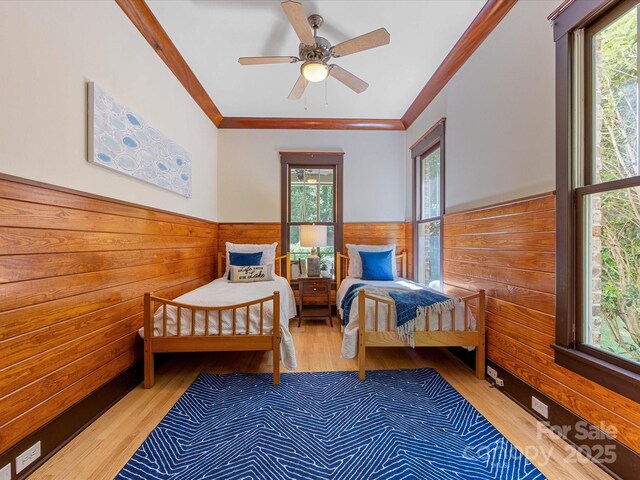 3825 Mountain Cove Dr, Charlotte, NC 28216 - bedroom with multiple windows, wooden walls, crown molding, a wainscoted wall, and wood finished floors