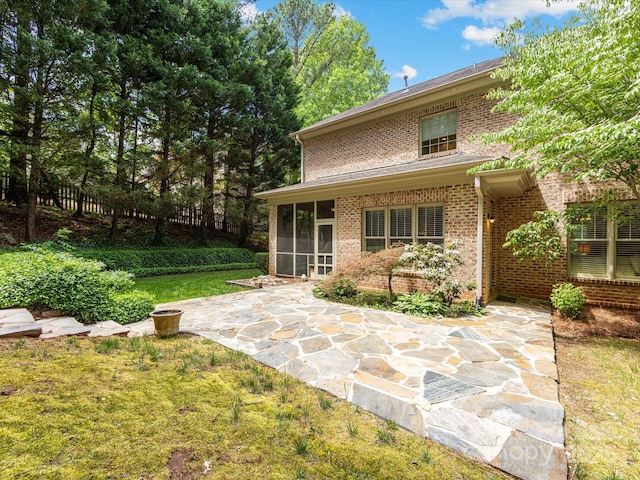 3825 Mountain Cove Dr, Charlotte, NC 28216 - rear view of house featuring a sunroom, brick siding, a lawn, and a patio area