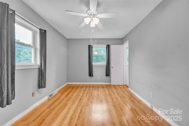 133 Jo Monni Loop, Statesville, NC 28625 - spare room with light wood-style floors, ceiling fan, a textured ceiling, and baseboards
