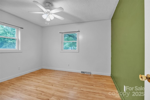 133 Jo Monni Loop, Statesville, NC 28625 - empty room featuring plenty of natural light, light wood-style floors, a textured ceiling, and baseboards