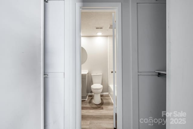 7129 Stonington Ln, Charlotte, NC 28227 - bathroom featuring toilet, wood finished floors, a textured ceiling, vanity, and a tub