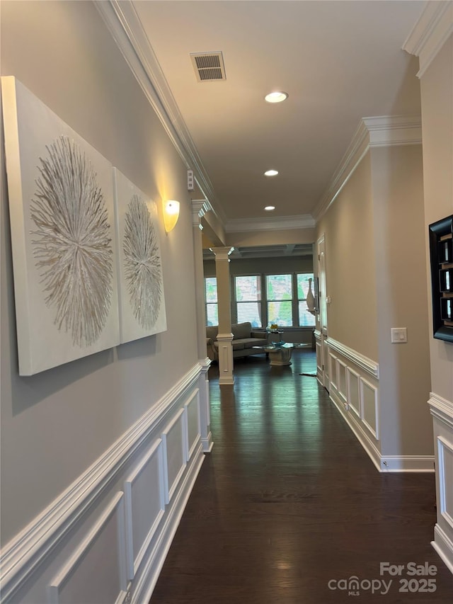 corridor with visible vents, a decorative wall, decorative columns, and ornamental molding