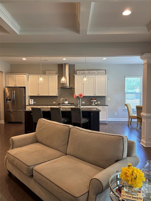 living room with crown molding, dark wood-style flooring, and a raised ceiling