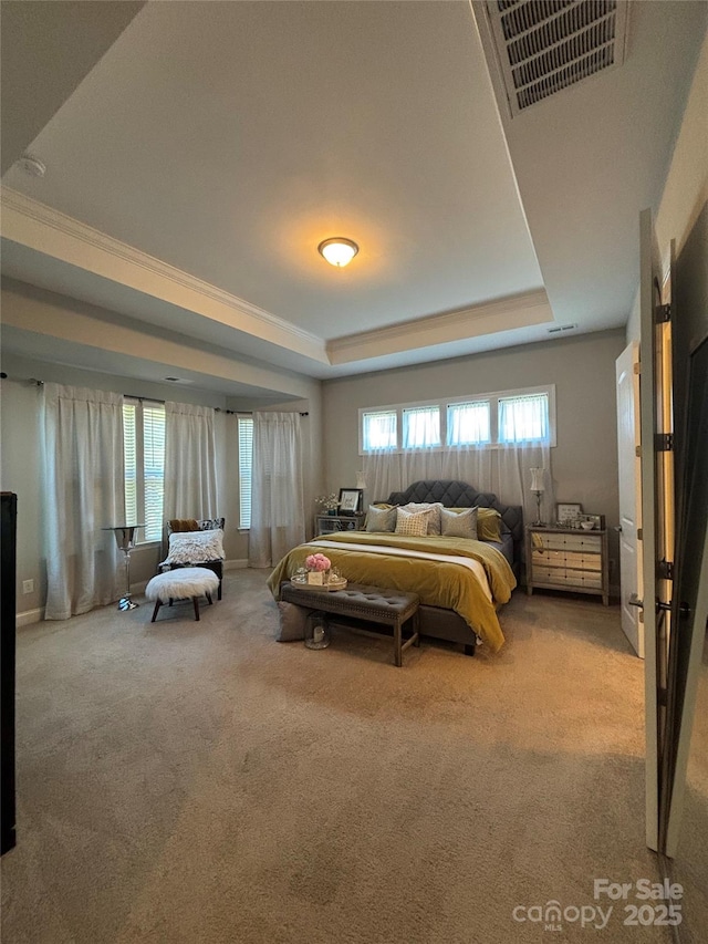 bedroom featuring carpet flooring, a tray ceiling, and visible vents