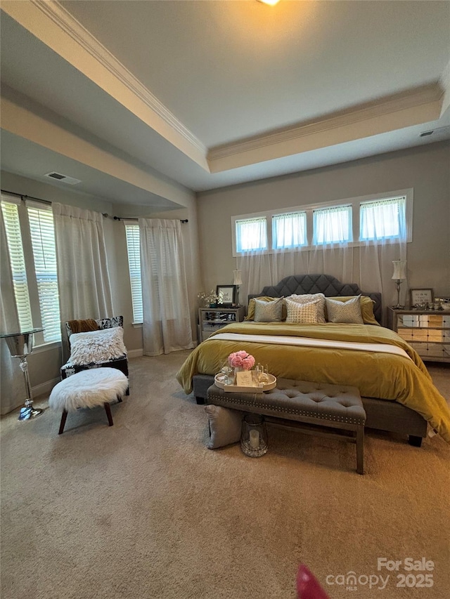 bedroom with ornamental molding, a tray ceiling, visible vents, and carpet