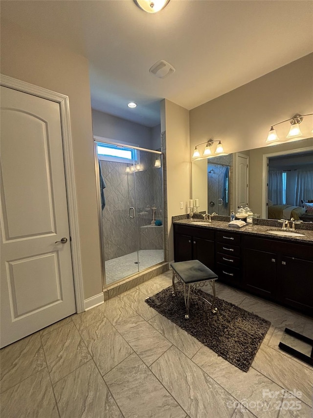 full bath featuring a shower stall, marble finish floor, double vanity, and a sink