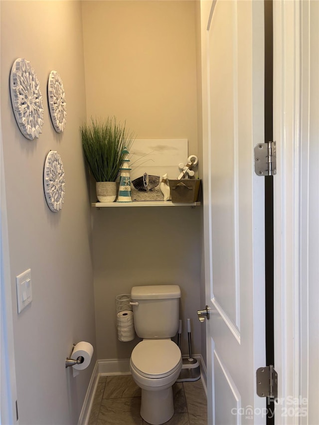bathroom featuring baseboards and toilet