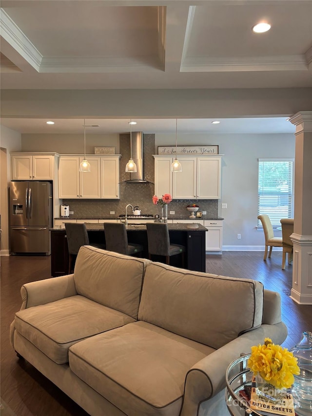 living room with dark wood-style flooring, a tray ceiling, and crown molding