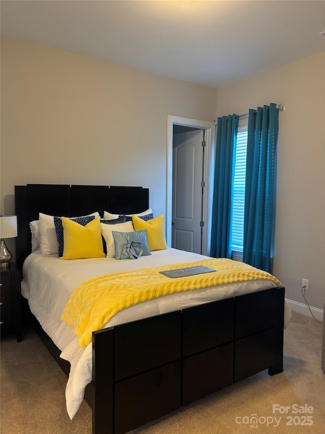 bedroom featuring baseboards and light carpet