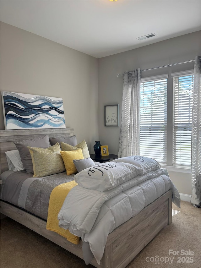carpeted bedroom featuring visible vents and baseboards