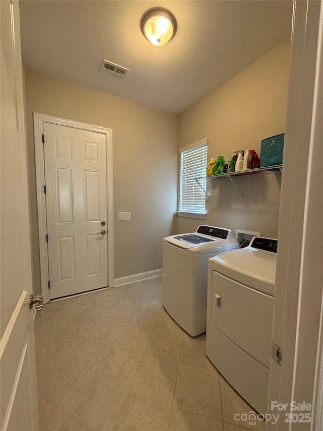 laundry area with independent washer and dryer, laundry area, light tile patterned flooring, visible vents, and baseboards