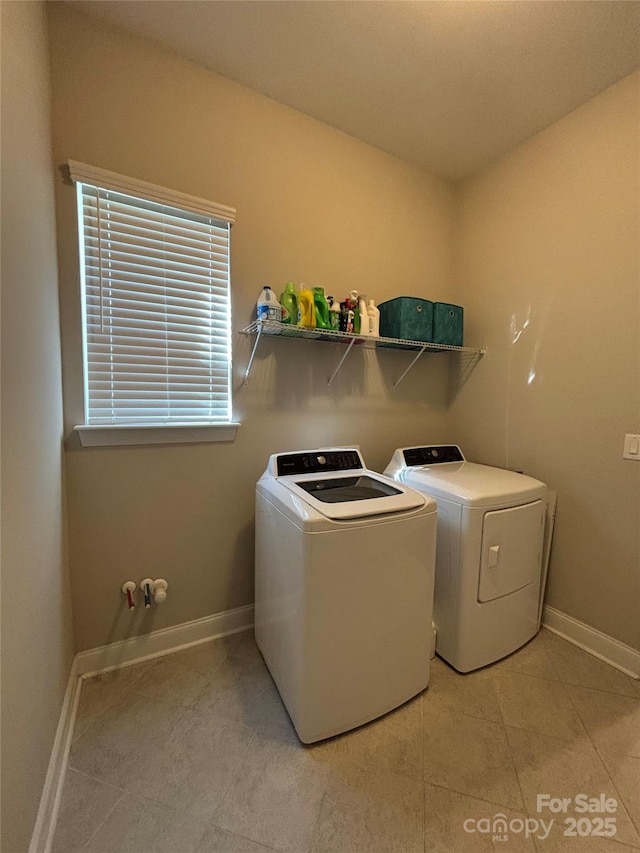 laundry area with light tile patterned flooring, laundry area, baseboards, and washing machine and dryer