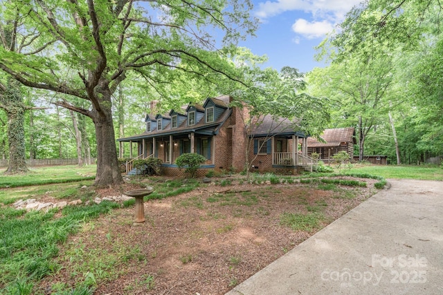 view of front facade with covered porch, fence, and a front lawn