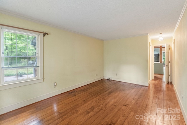 unfurnished room featuring ornamental molding, hardwood / wood-style floors, and a textured ceiling