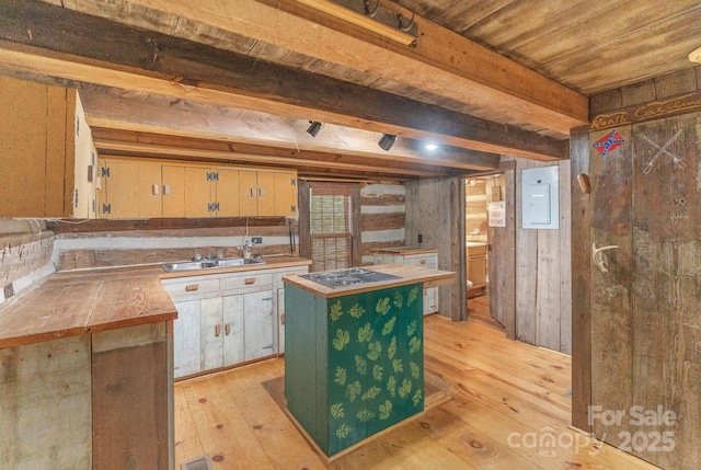 kitchen featuring electric cooktop, a kitchen island, light wood-style flooring, and a sink