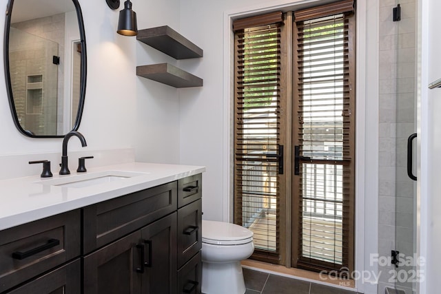 full bathroom with toilet, tile patterned floors, vanity, and a shower stall