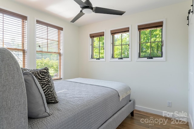 bedroom featuring baseboards, a ceiling fan, and wood finished floors
