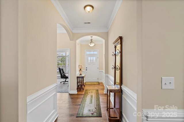 1409 Tupelo Rd, Clover, SC 29710 - foyer with arched walkways, crown molding, dark wood finished floors, wainscoting, and a decorative wall