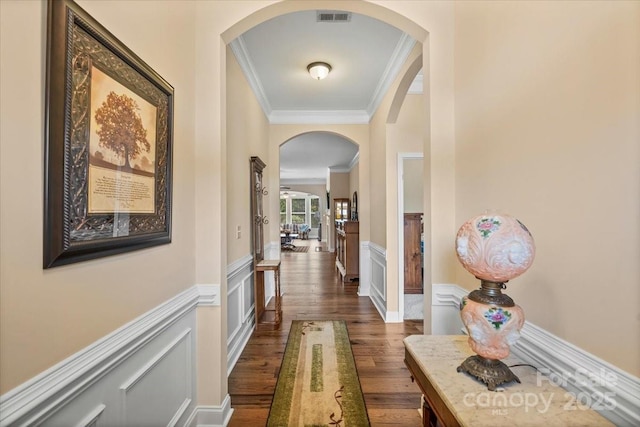 1409 Tupelo Rd, Clover, SC 29710 - hallway with arched walkways, ornamental molding, dark wood finished floors, wainscoting, and a decorative wall