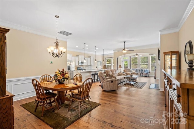 1409 Tupelo Rd, Clover, SC 29710 - dining room featuring ceiling fan, ornamental molding, wood-type flooring, a chandelier, and wainscoting