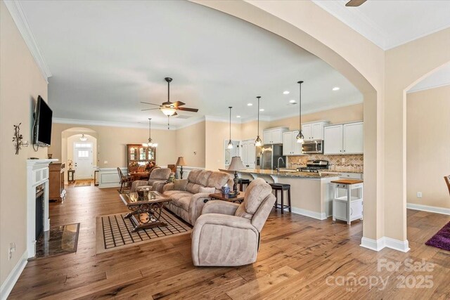 1409 Tupelo Rd, Clover, SC 29710 - living area featuring ceiling fan, arched walkways, ornamental molding, wood finished floors, and recessed lighting
