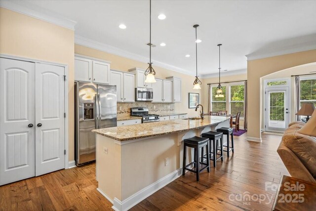 1409 Tupelo Rd, Clover, SC 29710 - kitchen with appliances with stainless steel finishes, a sink, crown molding, a spacious island, and a kitchen bar