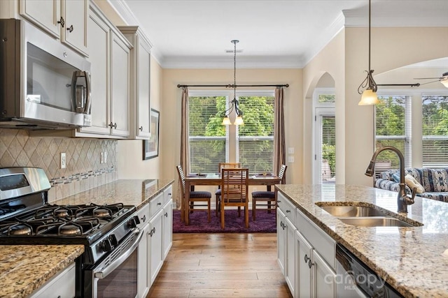 1409 Tupelo Rd, Clover, SC 29710 - kitchen featuring stainless steel appliances, a sink, light wood-type flooring, arched walkways, and hanging light fixtures