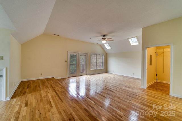 423 Baines Mountain Rd, Bryson City, NC 28713 - unfurnished living room with lofted ceiling with skylight, baseboards, light wood-type flooring, and a ceiling fan