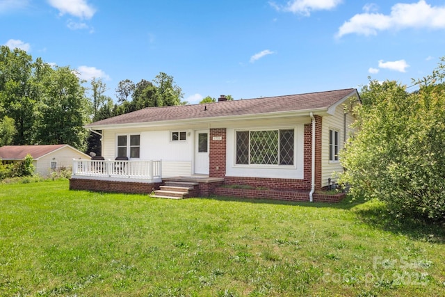 single story home with a front lawn, a chimney, a deck, and brick siding